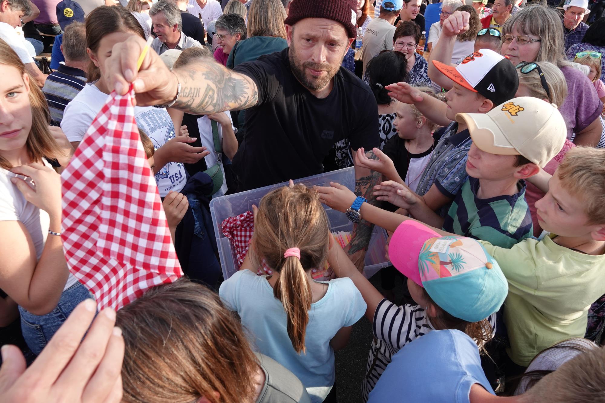 Die Fernseh-Crew verteilt heissbegehrte Fanartikel. Foto Roland Meyer